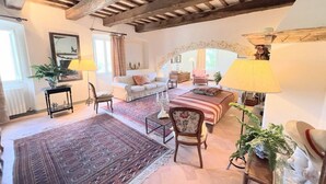 A cozy living room with a sofa, armchairs, a coffee table, and a patterned rug. - Adam House, exclusive Pool, outstanding views, vast garden, aircon, sleeps 8 (Provincia di Perugia)