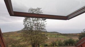 A view from a window with a brown frame, overlooking a landscape with trees and fields. - Studio Spacieux, Route des Vins (Rosheim)