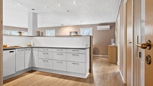 Eine moderne Küche mit weißen Schränken, Holzböden und einer Holzausstattung.
