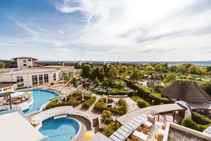 Un resort con una amplia piscina, zonas de estar al aire libre y vistas del paisaje circundante.