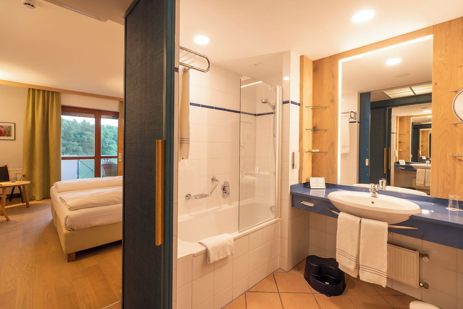 A modern hotel bathroom with a bathtub, shower, and sink.
