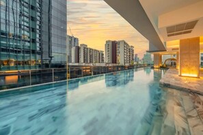Un edificio moderno con fachada de vidrio y zona de piscina.
