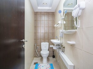 Un baño con inodoro, lavamanos y ducha.