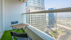 A balcony with a view of a modern building and a cityscape.