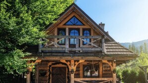 A rustic wooden cabin with a balcony, a large wooden door, and a chimney. - Mountain Shelter by Loft Affair (Zakopane)