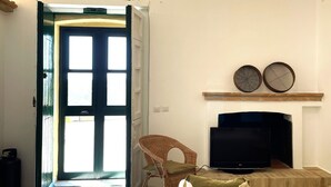 A room with a bed, a television, a chair, and a fireplace. - La Casedda Verde - Pisticci - nature and relaxation (Basilicata)