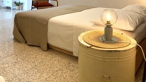 A bedroom with a bed, a nightstand with a lamp, a chair, a dresser, and a mirror on the wall. - La Casedda Verde - Pisticci - nature and relaxation (Basilicata)