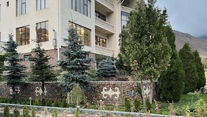 A multi-story building with a stone facade and a balcony. - Mountain View Hot Spring Resort (Koy-Tash)