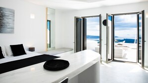 Un dormitorio moderno con una cama, una mesita de noche y un ventanal con vistas al mar.