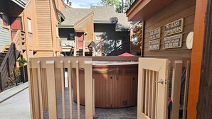 A wooden cabin with a wooden gate leading to a hot tub area. - Grand Mountain Getaway | Ski, Fireplace, EV Charger (Durango)