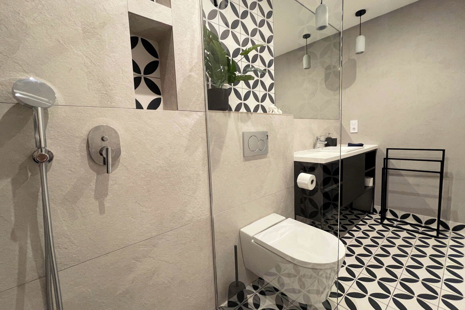 A modern bathroom with a shower, toilet, and sink.