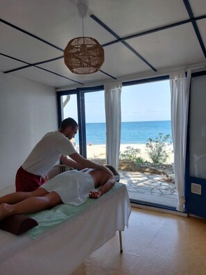 Een massageruimte met uitzicht op het strand.