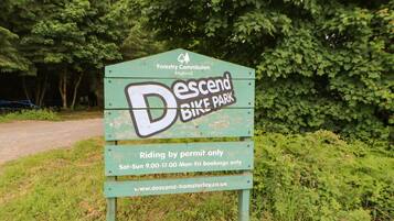 A sign for 'Descent Bike Park' with information about riding by permit and booking times.