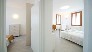 Une chambre d’hôtel avec un lit, une chaise, une petite table et un radiateur.