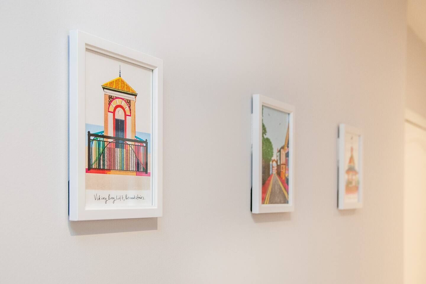 Tres obras de arte enmarcadas en una pared.