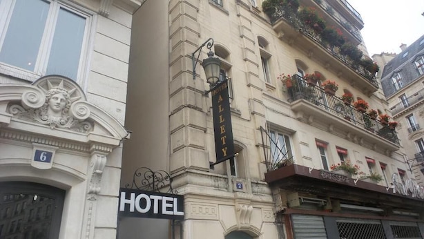 A hotel with a classic facade, a prominent sign, and a balcony with flowers. - Hotel Allety (Paris)