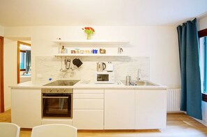 Een koelkast met diepvriezer, een microgolfoven, een oven, een kookplaat