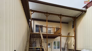 Un bâtiment à deux étages avec un escalier en bois menant à un balcon.