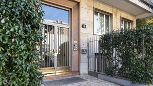 A building entrance with a metal gate, a tiled pavement, and a small step leading to the entrance. - notaMi - City Charme Studio (Milan)