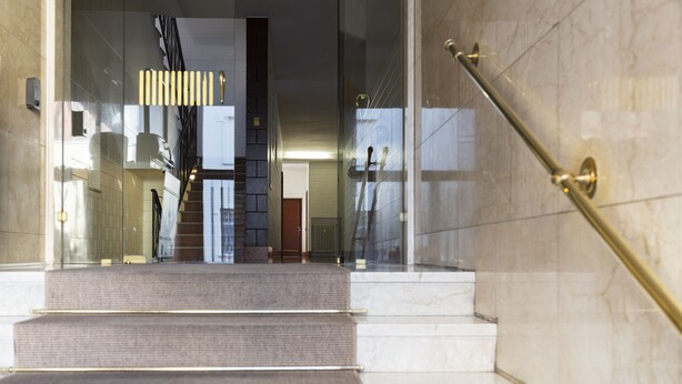 A staircase with marble steps and a glass railing, leading to an interior space with a modern design. - notaMi - City Charme Studio (Milan)
