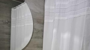 A bathroom with a wooden wall, a round mirror, a sink, and a toilet. - Apart Latitud (Santiago)