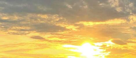 A sunset over a body of water with a distant shoreline.