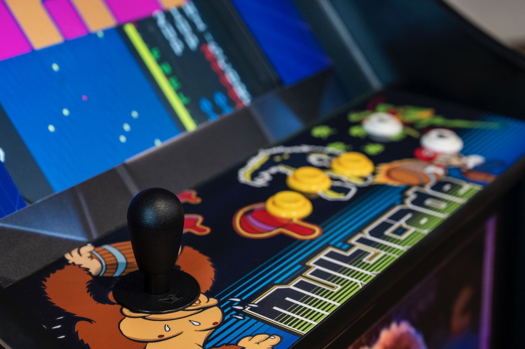 A close-up of a video game arcade machine with colorful graphics and a joystick.
