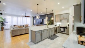A modern kitchen with grey cabinets, a central island, and pendant lighting. - Best of Midtown-3 Bedrooms, Minutes to Attractions (Houston)