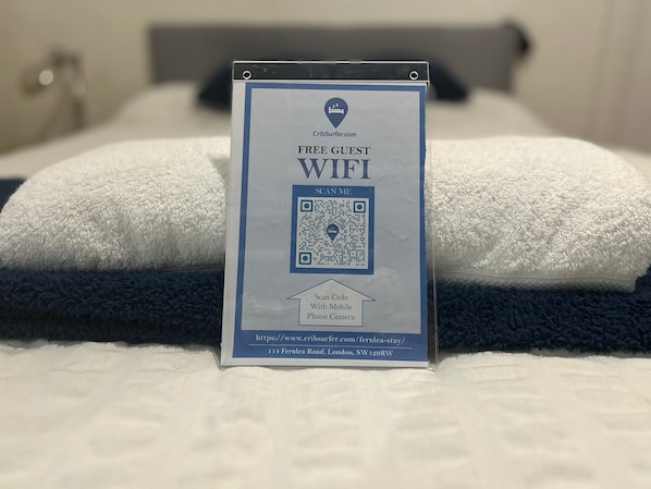 A sign offering free guest WiFi with a QR code for mobile access. - Balham Double Deluxe Room 2 (London)