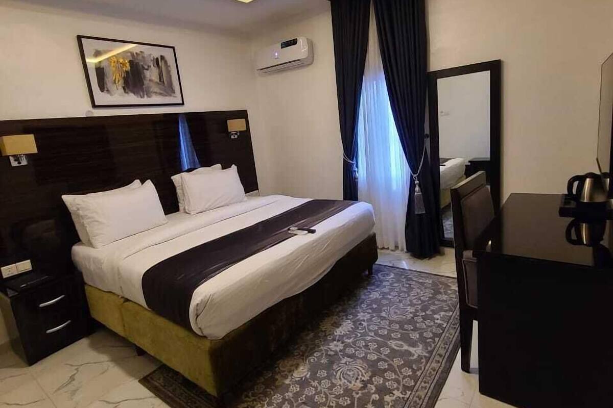 Une chambre d’hôtel moderne, dotée d’un grand lit, d’un bureau et d’une chaise.