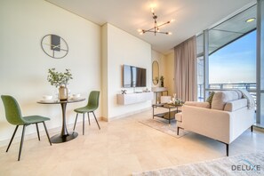 Relax in this stylish living room with a comfortable sofa set, dining table, and flat-screen TV.