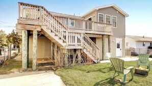 A two-story house with a wooden deck and a staircase leading to the second floor. - Mystic Island Bay Breeze, Beautiful waterfront sunsets waiting (Little Egg Harbor Township)