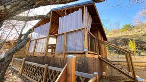 Eine Holzhütte mit überdachter Veranda und einem eingezäunten Bereich.
