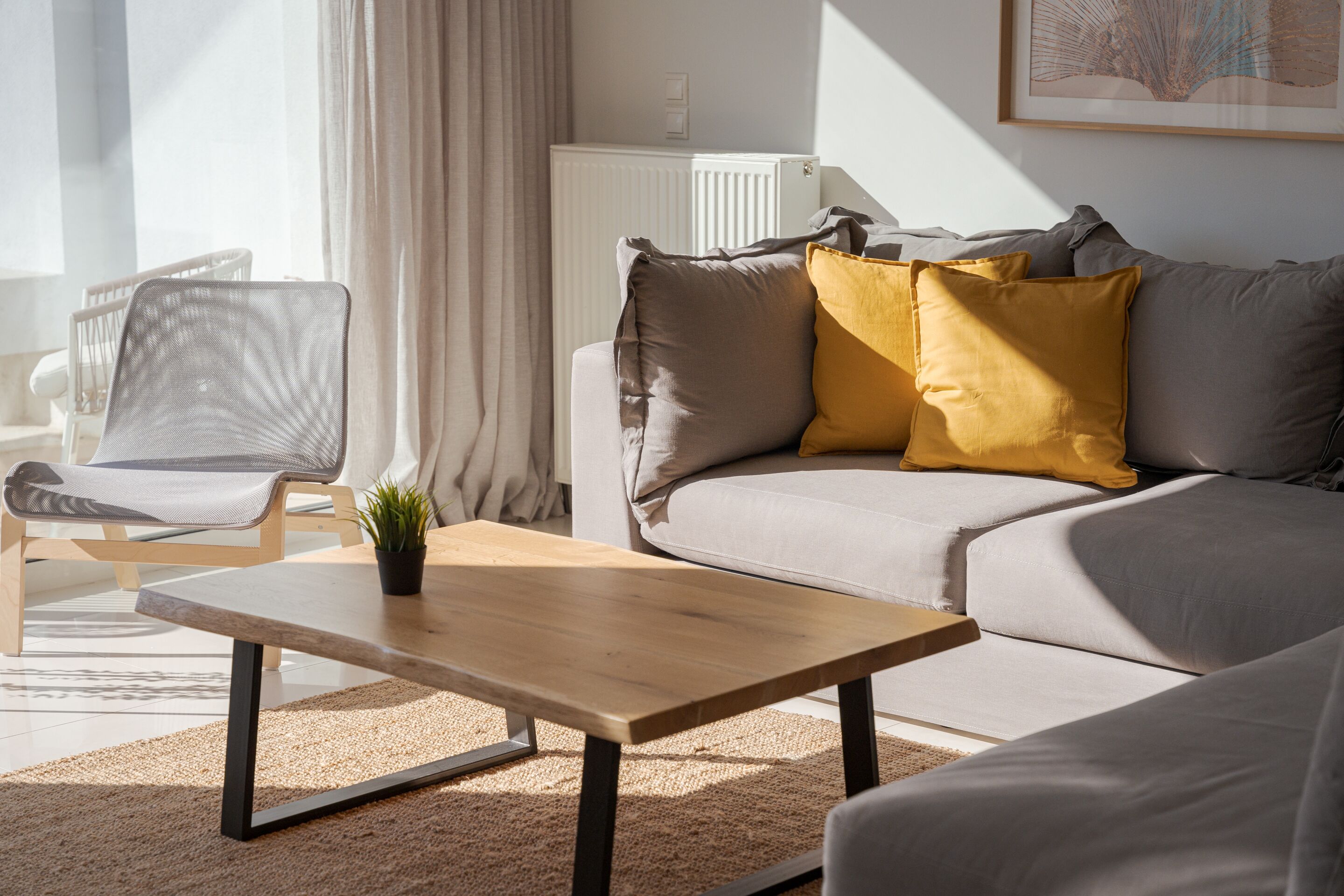 A modern living room with a sofa, a wooden coffee table, and a chair.