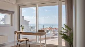 Una camera moderna con un'ampia porta-finestra scorrevole che si apre su un balcone con vista sul mare.