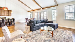 A spacious living room with a sectional sofa, a glass coffee table, and a dining area with a kitchen in the background. - Francis Townhome: 5 Mi to Park City Mountain! (Heber City)