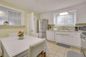 A modern kitchen with white cabinets, a stainless steel refrigerator, a microwave, and a sink. - 5 Mi to City Park: New Orleans Area Home (Metairie)