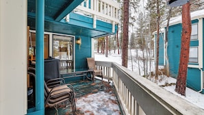 A covered porch with chairs and a table, surrounded by snow-covered trees. - Meadow Creek Golf Resort Condo: Skiing & Lake Life (New Meadows)