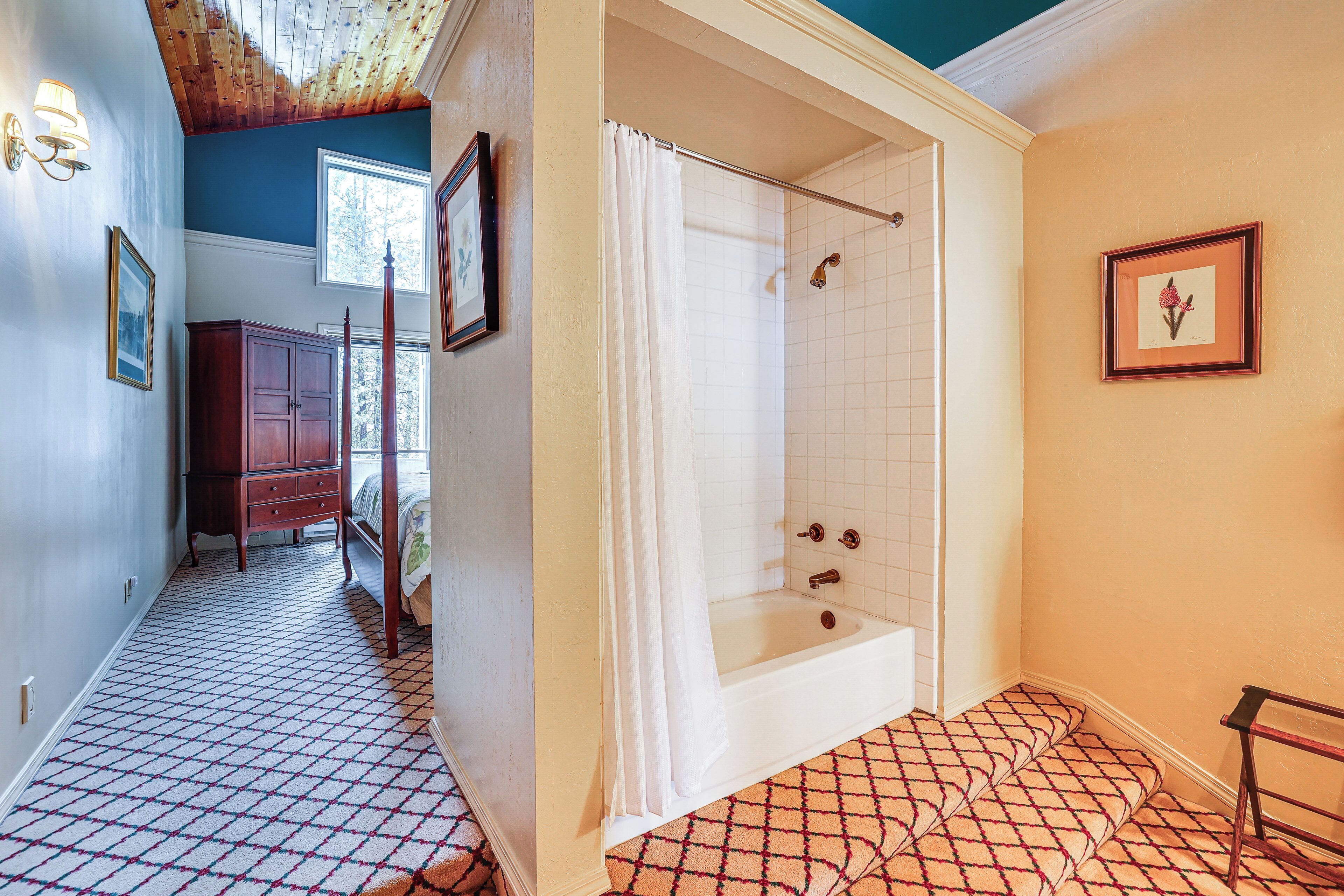 A bathroom with a bathtub, a shower, and a patterned floor.