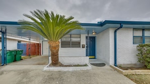A building with a white exterior and blue trim, a palm tree in the center, and a blue door. - 5 Mi to City Park: Charming Home Near Nola! (Metairie)