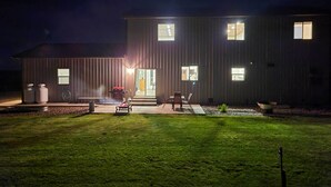 Un bâtiment moderne doté d’un hall d’entrée bien éclairé, d’un patio aménagé avec du mobilier d’extérieur et d’une pelouse verdoyante.