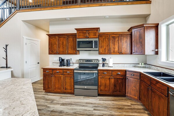 A kitchen with wooden cabinets, a stainless steel oven, and a microwave.