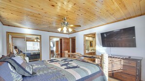 A bedroom with a large bed, wooden ceiling, a ceiling fan, a flat-screen TV, and a dresser. - Big Bear Lake Cabin w/ Hot Tub & Gas Fire Pit! (Big Bear Lake)