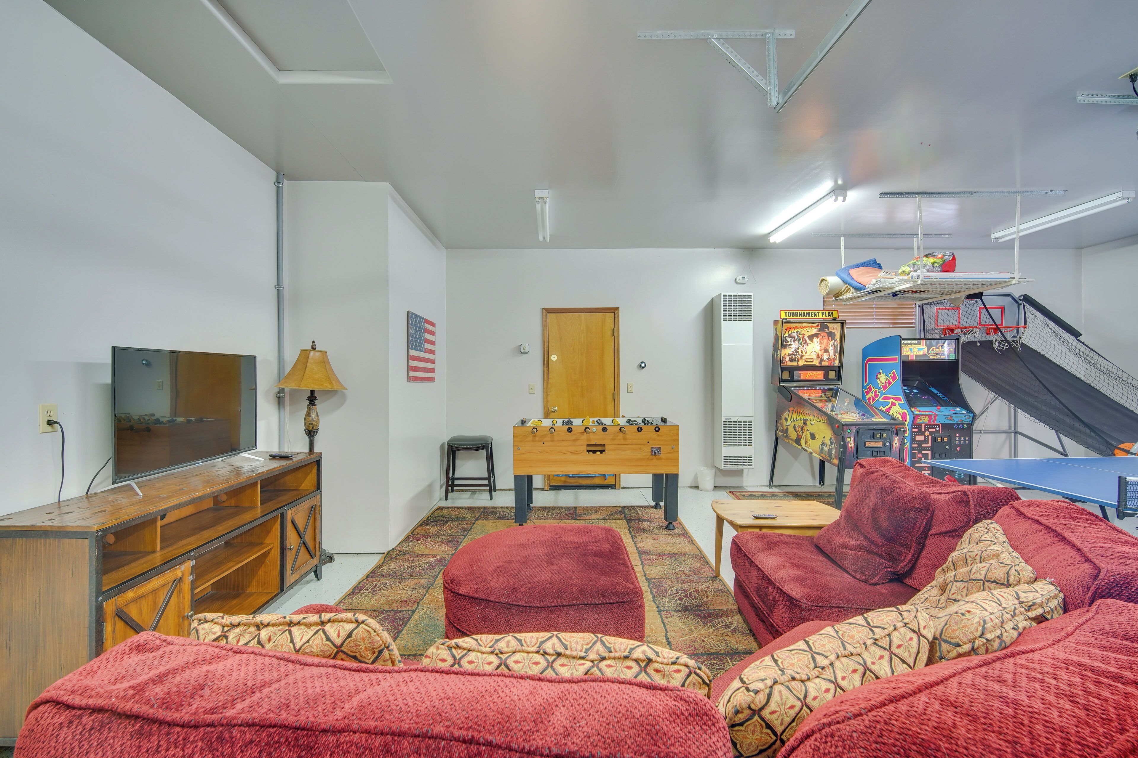 A living room with a foosball table, a television, and a sofa.