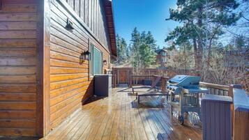 A wooden deck with a barbecue grill and outdoor seating.