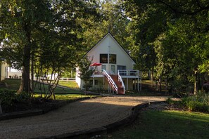 A two-story house with a covered porch and a staircase leading to the upper floor.