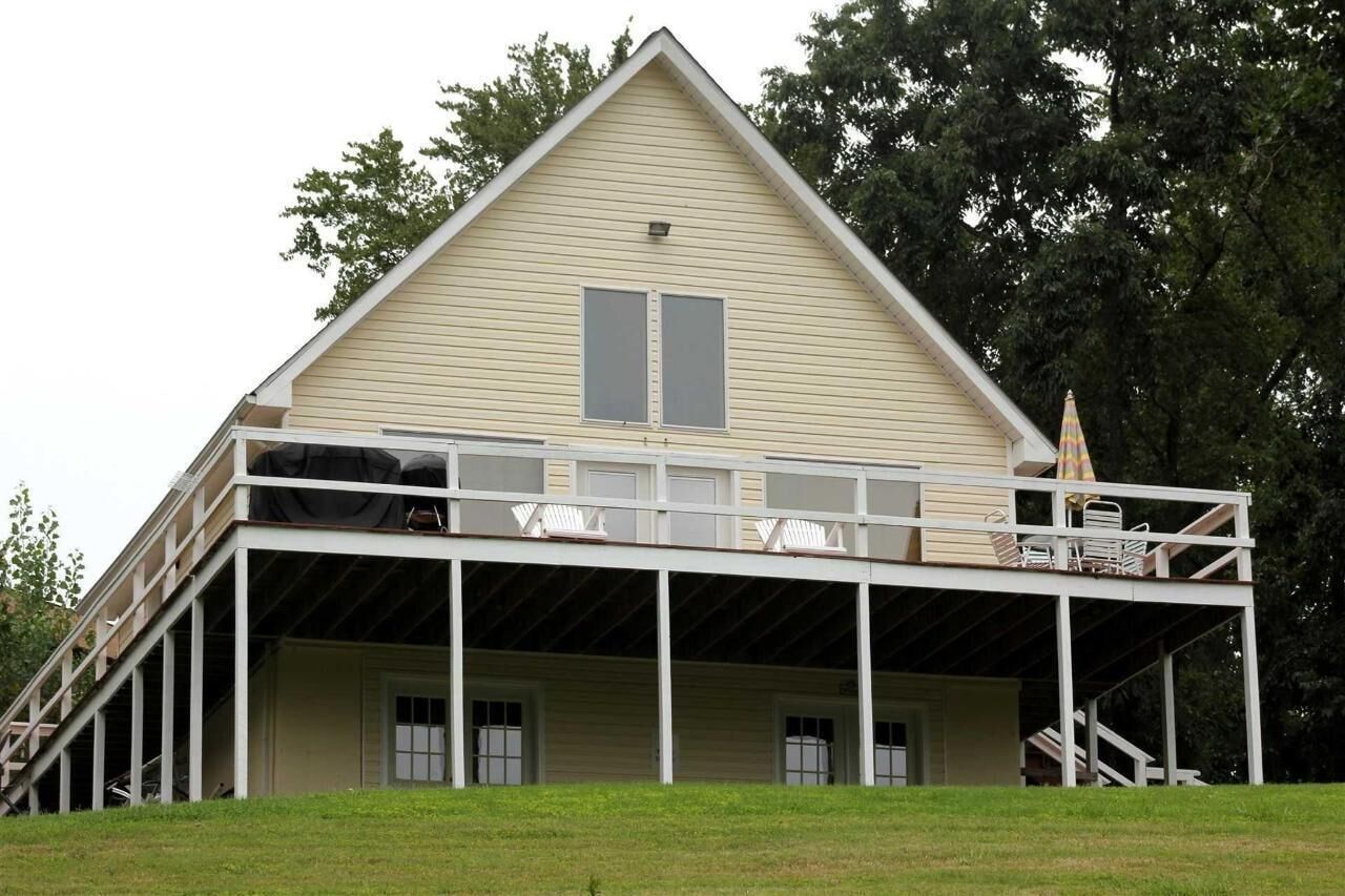 A two-story building with a balcony, a covered porch, and a staircase leading to the upper level.