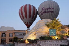 Two hot air balloons, one with 'Flower Balloons' written on it, and a sign for 'Zemi Hotel Cappadocia' in the foreground. - Zemi Hotel Cappadocia (Nevsehir)