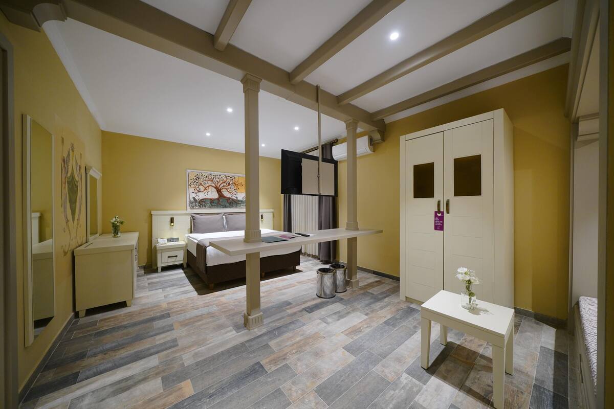 A bedroom with a bed, bedside tables, a wardrobe, and a desk with a chair.