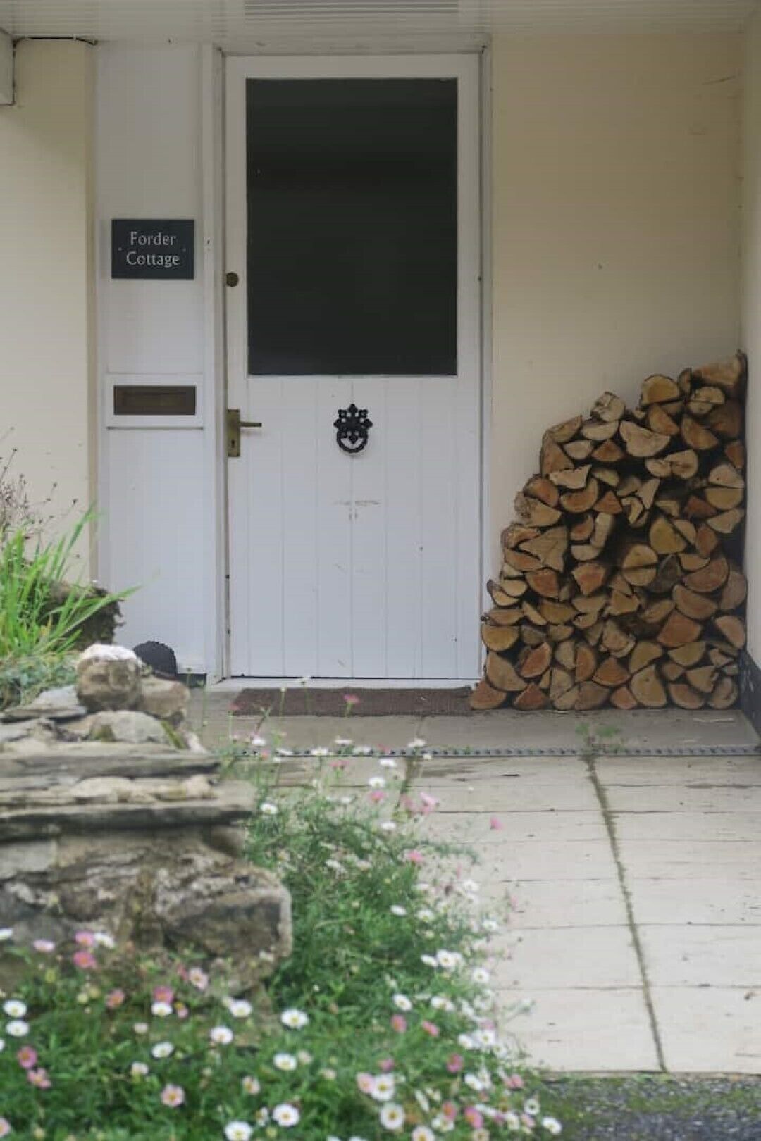 Eine weiße Tür mit einem schwarzen Fenster und einem Schild mit der Aufschrift "Forder Cottage".